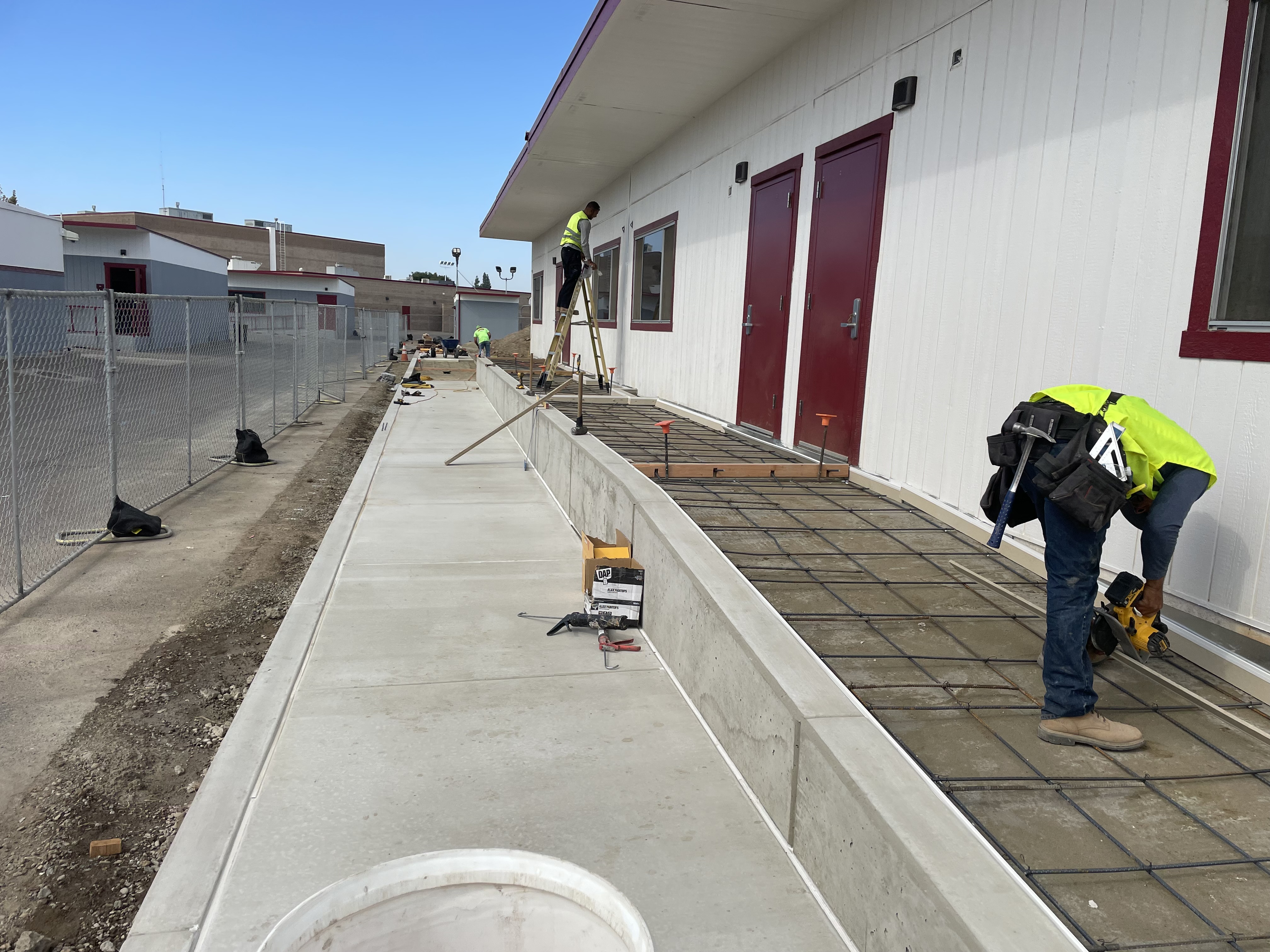 Crew installing ADA-compliant concrete pathway and sidewalk at commercial school facility