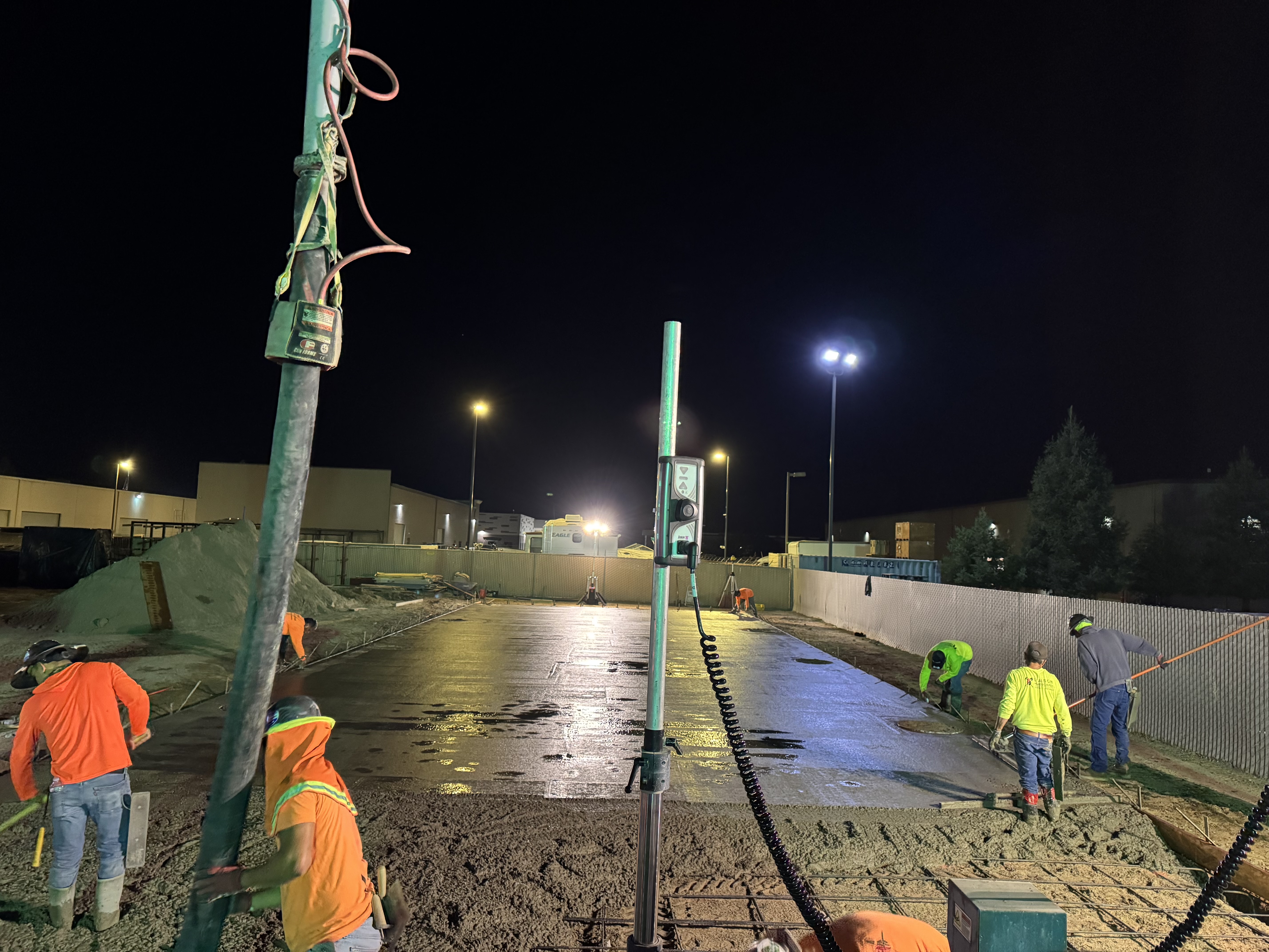 Crew finishing concrete parking lot at night on commercial project in Northern California