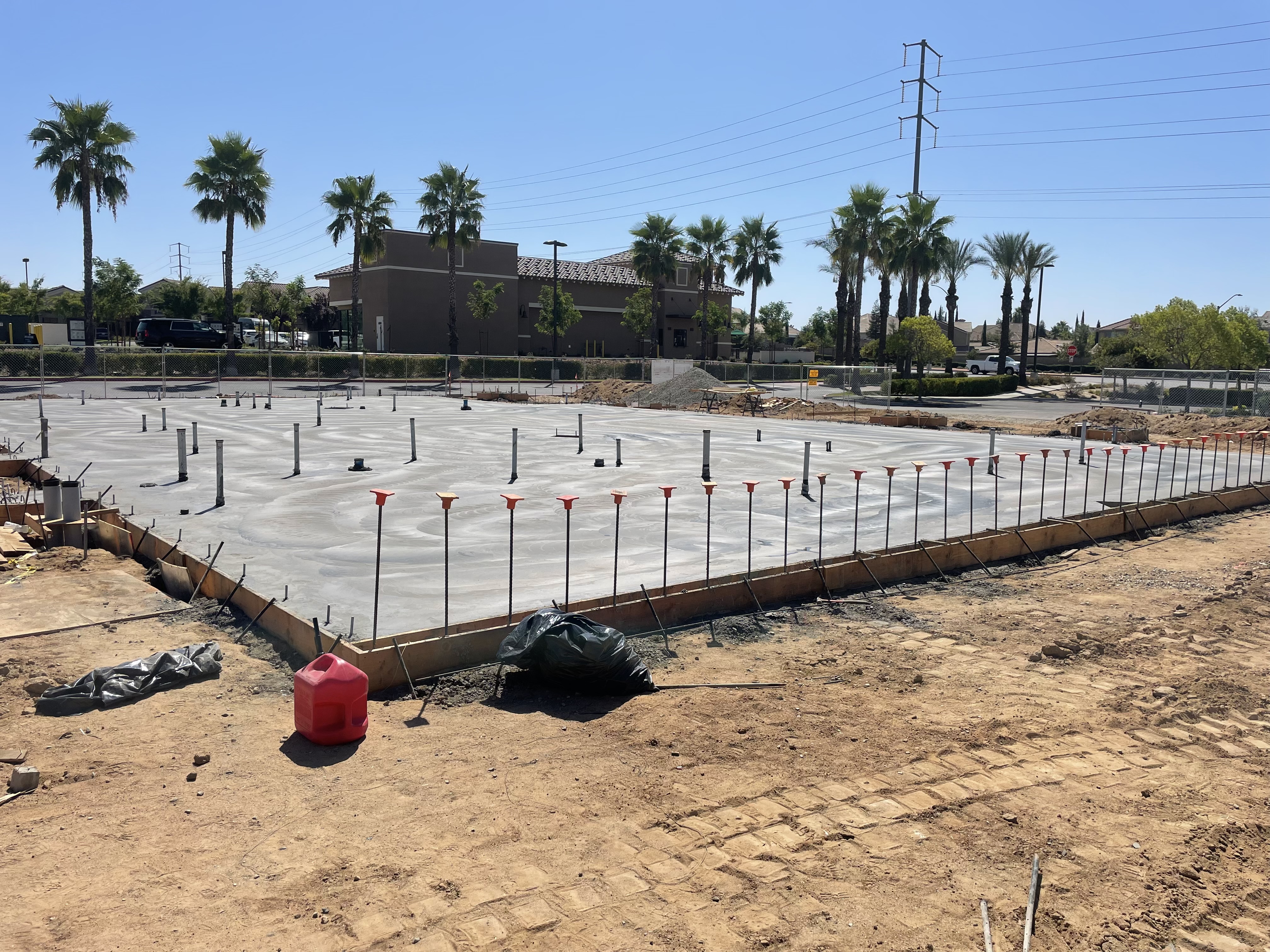Freshly poured commercial foundation slab with anchor bolts in Central Valley, California
