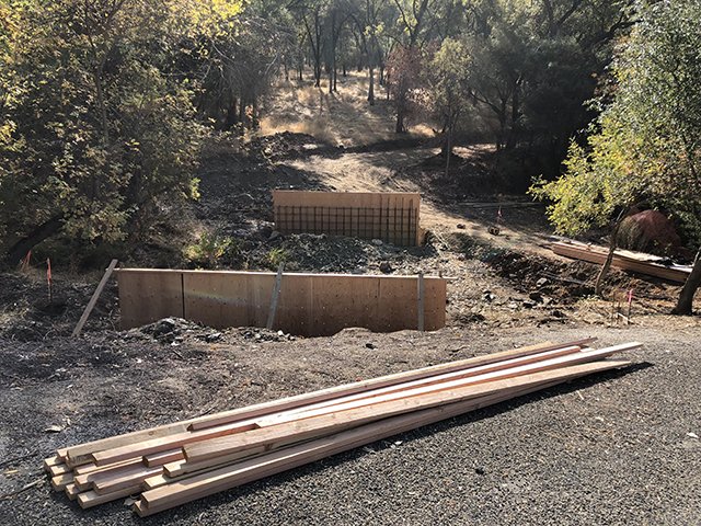 Concrete formwork and rebar installation for a commercial retaining wall on a grading project